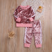 Pink velvet kids tracksuit with white stripes, cozy lounge wear set on wooden floor