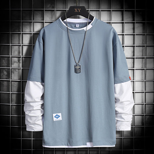 Light blue long-sleeve shirt with white accents, dog tag necklace, and grid background