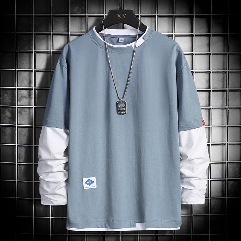Light blue long-sleeve shirt with white accents, dog tag necklace, and grid background