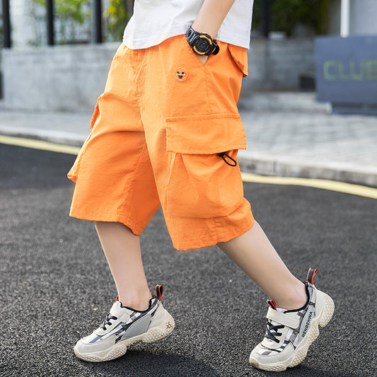 Bright orange cargo shorts with large pockets, paired with white sneakers, ideal for casual summer wear.