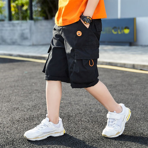 Black cargo shorts with emoji patch, worn with orange tee and white sneakers for kids' streetwear style
