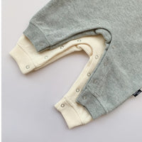 Soft gray and cream baby onesies with snap closures, cozy infant clothing for newborns