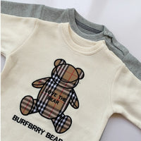 Cream baby onesie with plaid teddy bear graphic, 'Love the Bear' text, and 'BURBERRY BEAR' print