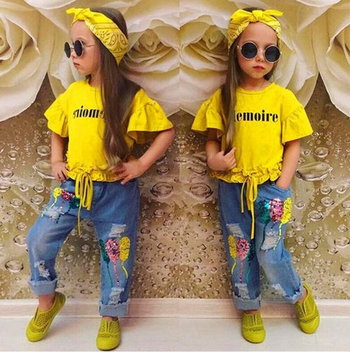 Kids in yellow ruffle tops, floral jeans, and sunglasses for trendy fashion looks