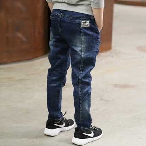 Boy wearing blue denim trousers from Ancient Energy, children's casual denim pants, front view showing fit and style.