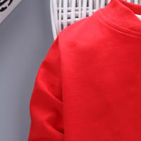Children's three-piece clothing set by Ancient Energy, featuring colorful tops and pants for kids, displayed on a white background.
