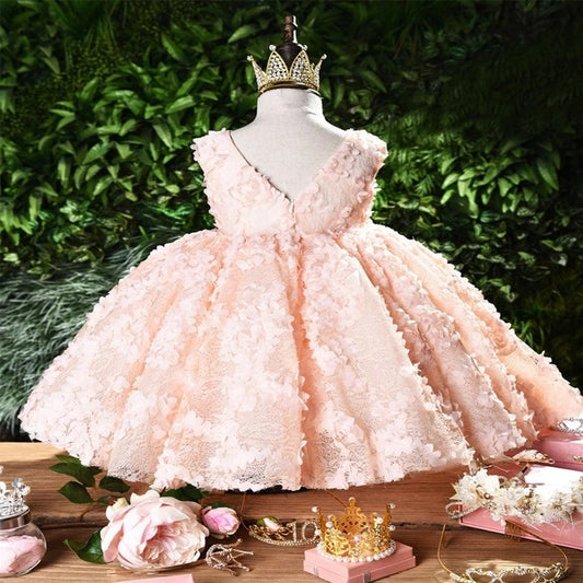 Baby girl dress for one-year-old by Ancient Energy, soft pastel-colored with ruffles and floral details.