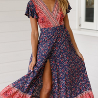 Tropical Bloom Maxi Dress by Mandotos International featuring vibrant floral print, flowing fabric, and sleeveless design.