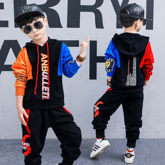 Boy wearing a spring Korean children's sports two-piece suit by Ancient Energy, long-sleeved top and pants in vibrant colors.