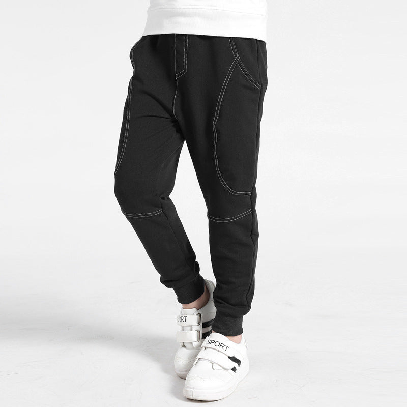 Boy wearing Ancient Energy boys' sports trousers, lightweight athletic pants with elastic waistband and sporty design.