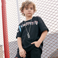 Children's printed T-shirt by Ancient Energy featuring colorful cartoon designs on soft fabric.