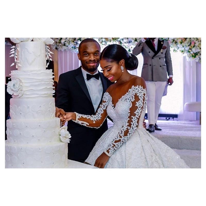 Elegant custom wedding gown by Ancient Energy featuring intricate lace details and a flowing train for bridal elegance.