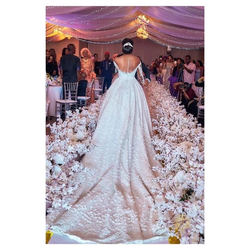Elegant custom wedding gown by Ancient Energy featuring intricate lace and flowing fabric, perfect for a bridal dress.