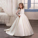 Little girl wearing a champagne long sleeve dress by Ancient Energy, soft fabric and elegant style for special occasions.