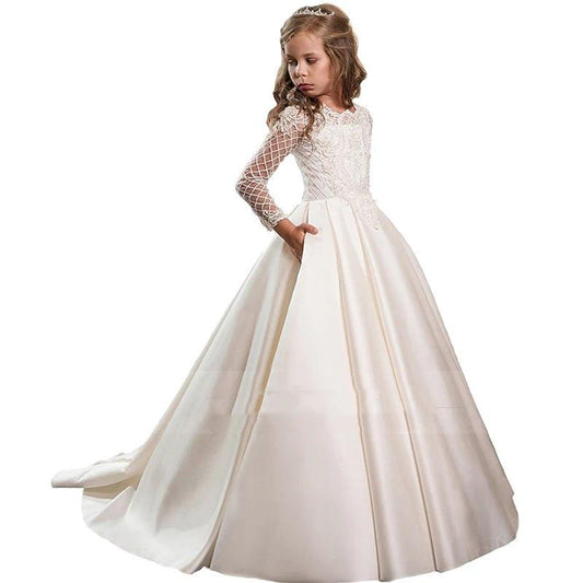 Little girl wearing a champagne-colored long sleeve dress from Ancient Energy, featuring a soft, elegant design.