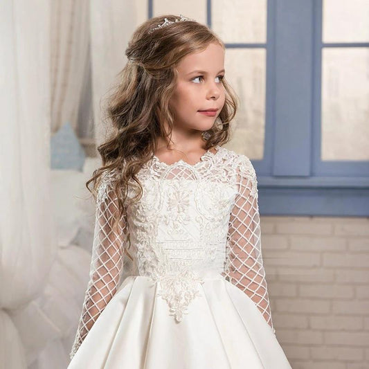 Little girl wearing a champagne-colored long sleeve dress by Ancient Energy, featuring soft fabric and elegant design.