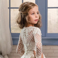 Little girl wearing a champagne-colored long sleeve dress by Ancient Energy, showcasing elegant fabric and a comfortable fit.