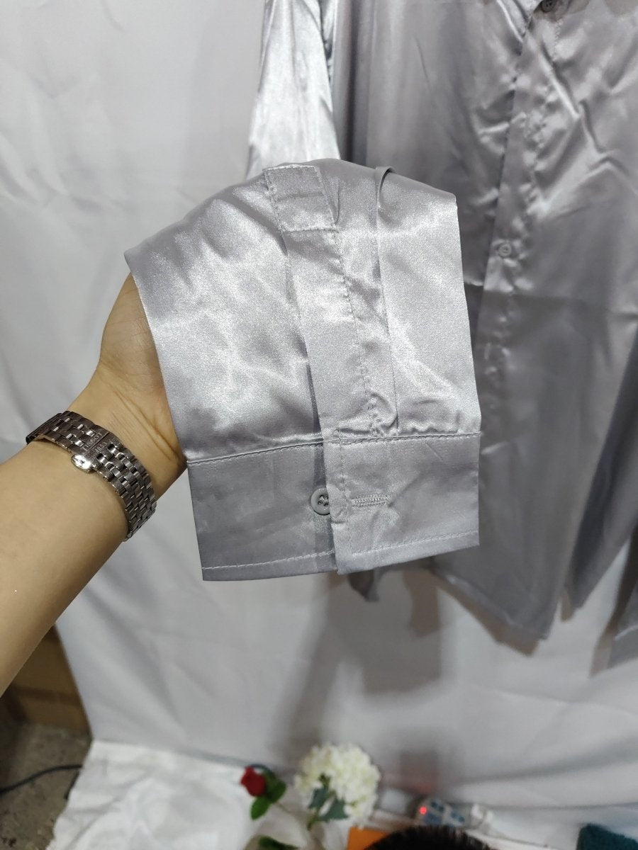 Mens black satin dress shirt by Ancient Energy, close-up of sleek black fabric and classic collar on the stylish shirt.