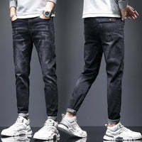 Mens ripped denim jeans with cat-whisker scratches from Ancient Energy, showing distressed fabric and stylish design details.