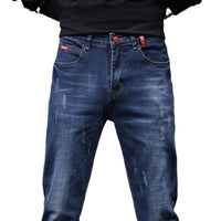 Men's ripped denim jeans by Ancient Energy featuring cat-whisker scratch distressing and frayed details for a rugged look.