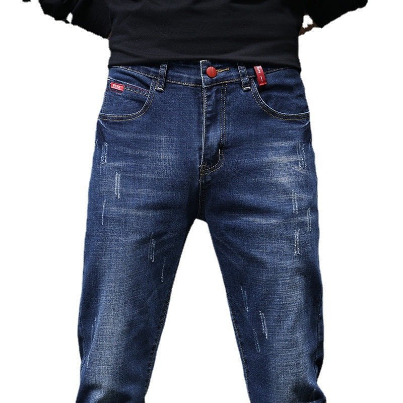 Men's ripped denim jeans by Ancient Energy featuring cat-whisker scratch distressing and frayed details for a rugged look.