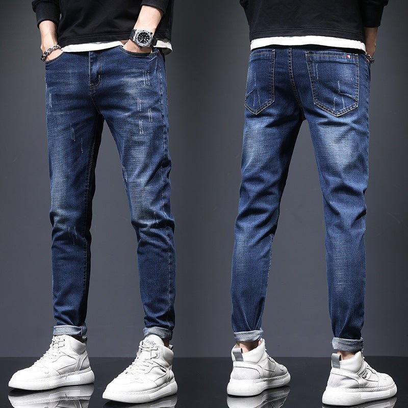 Men's ripped denim jeans by Ancient Energy featuring cat-whisker scratches and distressed details on classic blue denim.