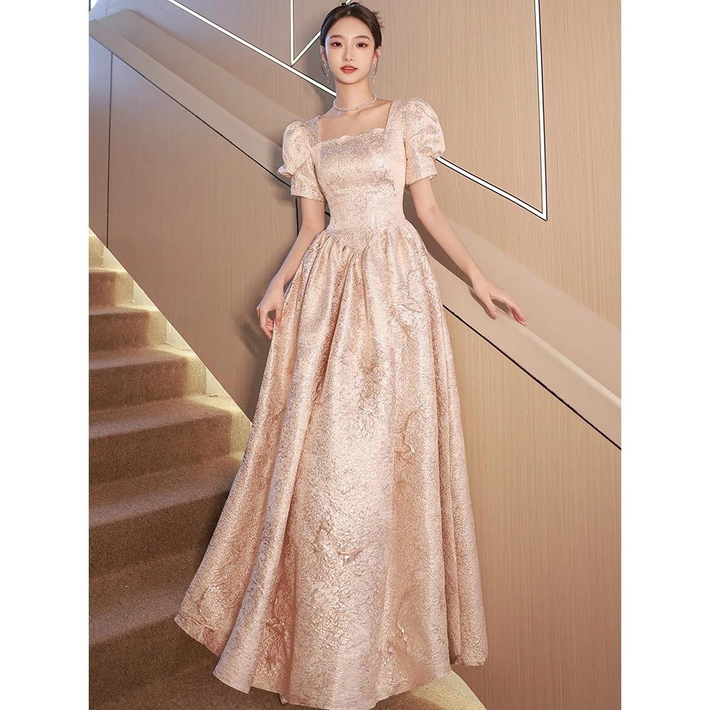Women’s champagne evening dress by Ancient Energy featuring elegant design and flowing fabric for formal occasions.