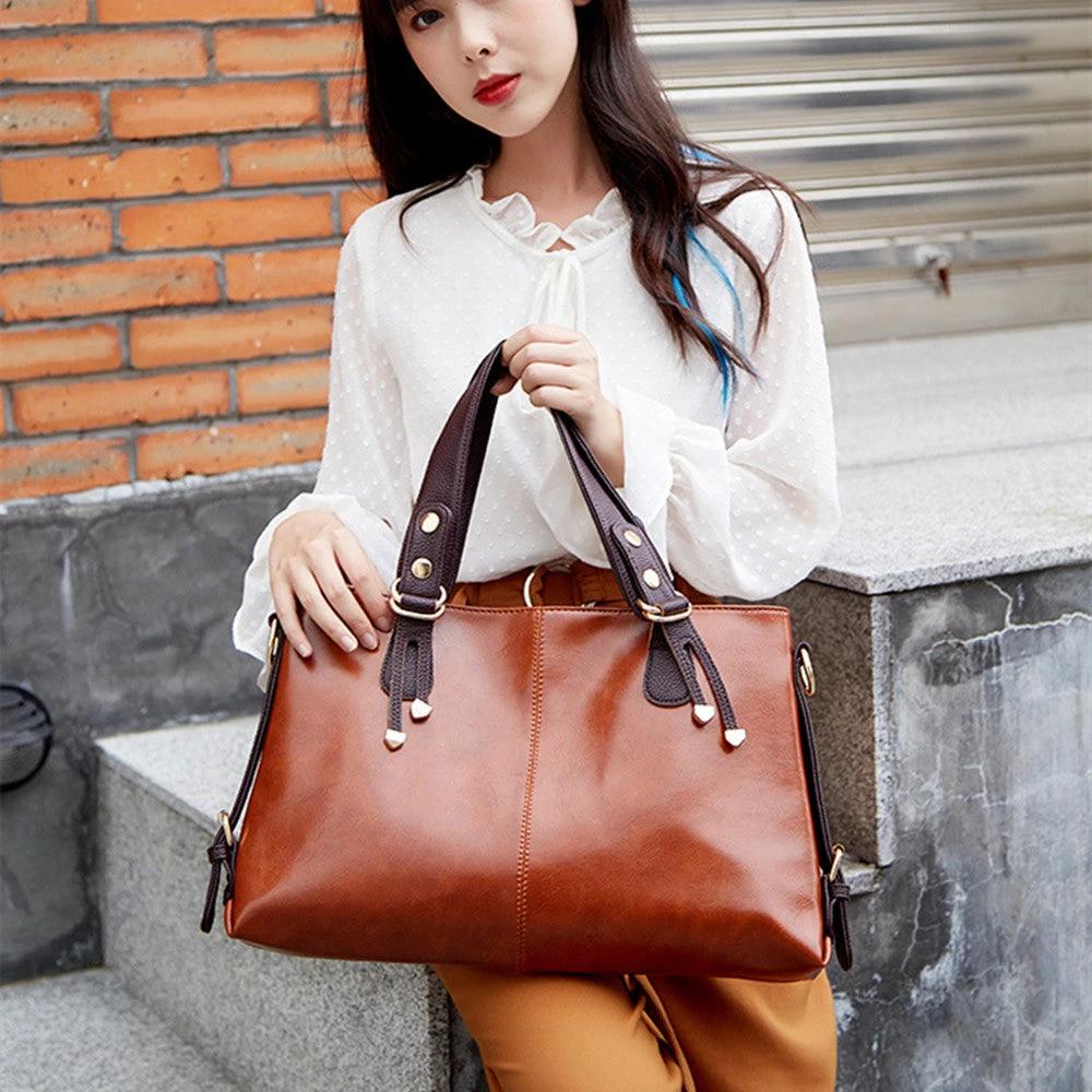 Women's large capacity soft leather shoulder messenger handbag by Ancient Energy with multiple compartments and adjustable strap.