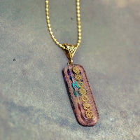 7 chakra Orgone copper pendant with chain from Ancient Energy, featuring colorful chakra stones and intricate metalwork.
