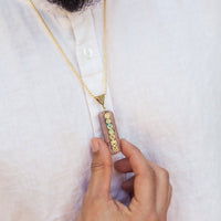 Seven chakra orgone copper pendant with chain, featuring colorful chakra stones and intricate design, on a black background.