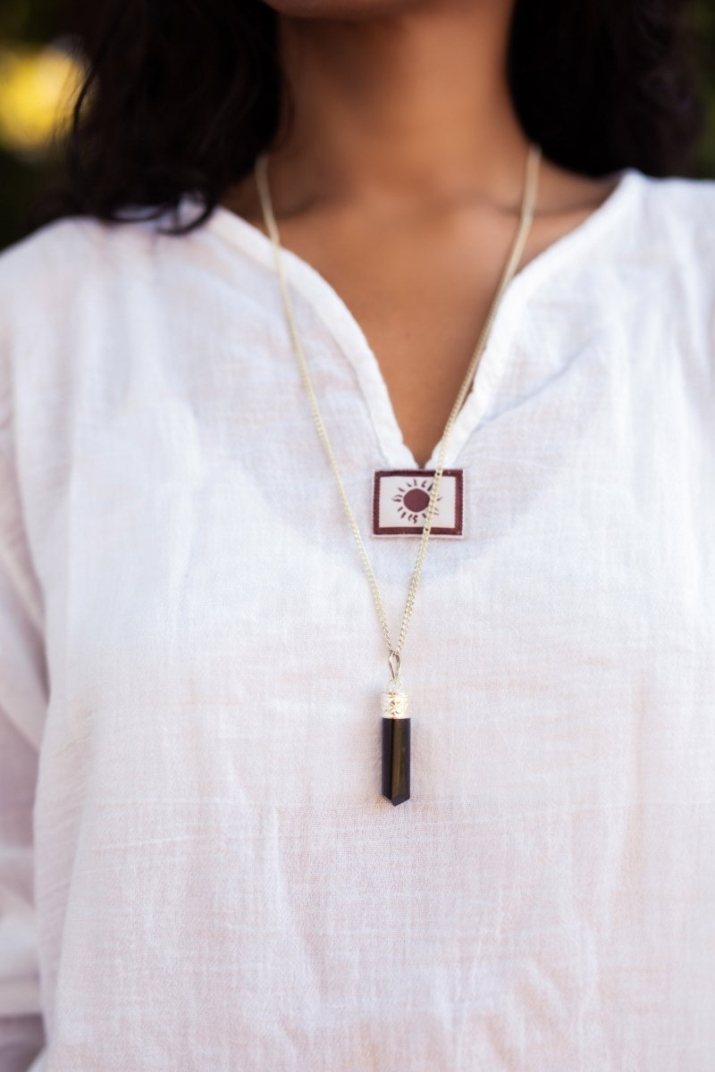 Silver-plated Black Tourmaline protection pendant from Ancient Energy featuring a polished stone and intricate silver setting.