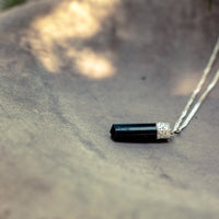Silver-plated Black Tourmaline Protection Pendant from Ancient Energy, showcasing a polished black tourmaline stone on a silver chain.