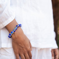Ancient Energy Evil Eye Protection Bracelet featuring blue and white beads on a leather cord for warding off negative energy.