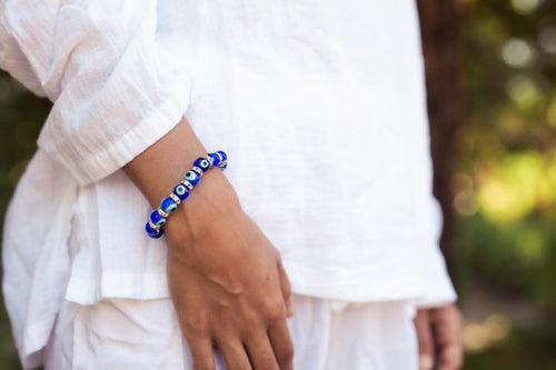 Ancient Energy Evil Eye Protection Bracelet featuring blue and white beads on a leather cord for warding off negative energy.