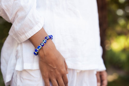 Ancient Energy Evil Eye Protection Bracelet featuring blue and white beads on a leather cord for warding off negative energy.