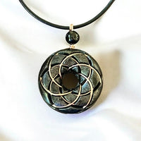 Ancient Energy Torus Vortex pendant necklace featuring Shungite orgonite and Rodin coil design, resting against a neutral background.