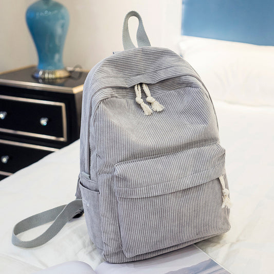 Ancient Energy corduroy backpack for students with shoulder straps, school bag design, front zip pocket, and durable fabric.