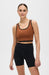 Elastique Athletics Lisse Bra in chestnut and black, shown as a stylish, fitted sports top for active wear.