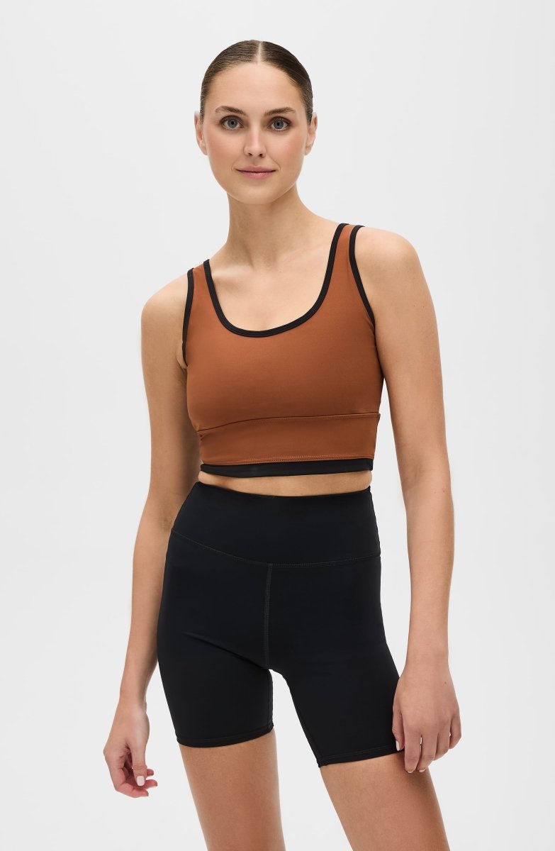 Elastique Athletics Lisse Bra in chestnut and black, shown as a stylish, fitted sports top for active wear.