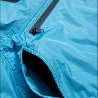 IWOM WeatherShield Convertible Jacket shown outdoors with adjustable hood and multiple zippered pockets for versatile weather protection.