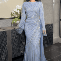 Iyza Belaar Abira sequin modest neckline long sleeve dress with embellished details and side skirt, elegant evening wear.