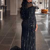 Iyza Belaar Hosna long sleeve dress with drape and sequin embellishments, featuring a modest design perfect for special occasions.