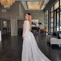 Aleena bridal long dress by Iyza Belaar with pearl and crystal embellishments, beaded details, and a detachable overskirt.