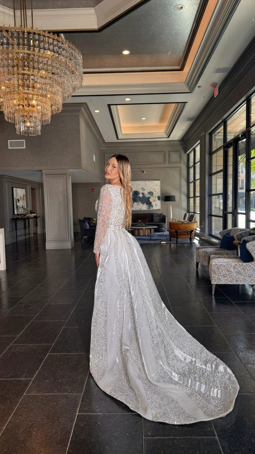 Aleena bridal long dress by Iyza Belaar with pearl and crystal embellishments, beaded details, and a detachable overskirt.