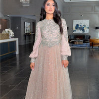 Iyza Belaar Bashira long sleeve embellished sequin modest ball gown, elegant evening dress with intricate detailing and flowing fabric.