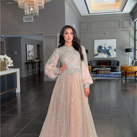 Iyza Belaar Bashira long sleeve embellished sequin modest ball gown, elegant evening dress with intricate beadwork and flowing fabric.