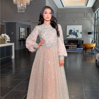 Iyza Belaar Bashira long sleeve embellished sequin modest ball gown, elegant evening dress with intricate detail and flowing fabric.