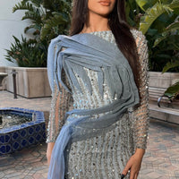Iyza Belaar Imani long sleeve side skirt dress, a stylish long dress with side slit and elegant design on the fabric.