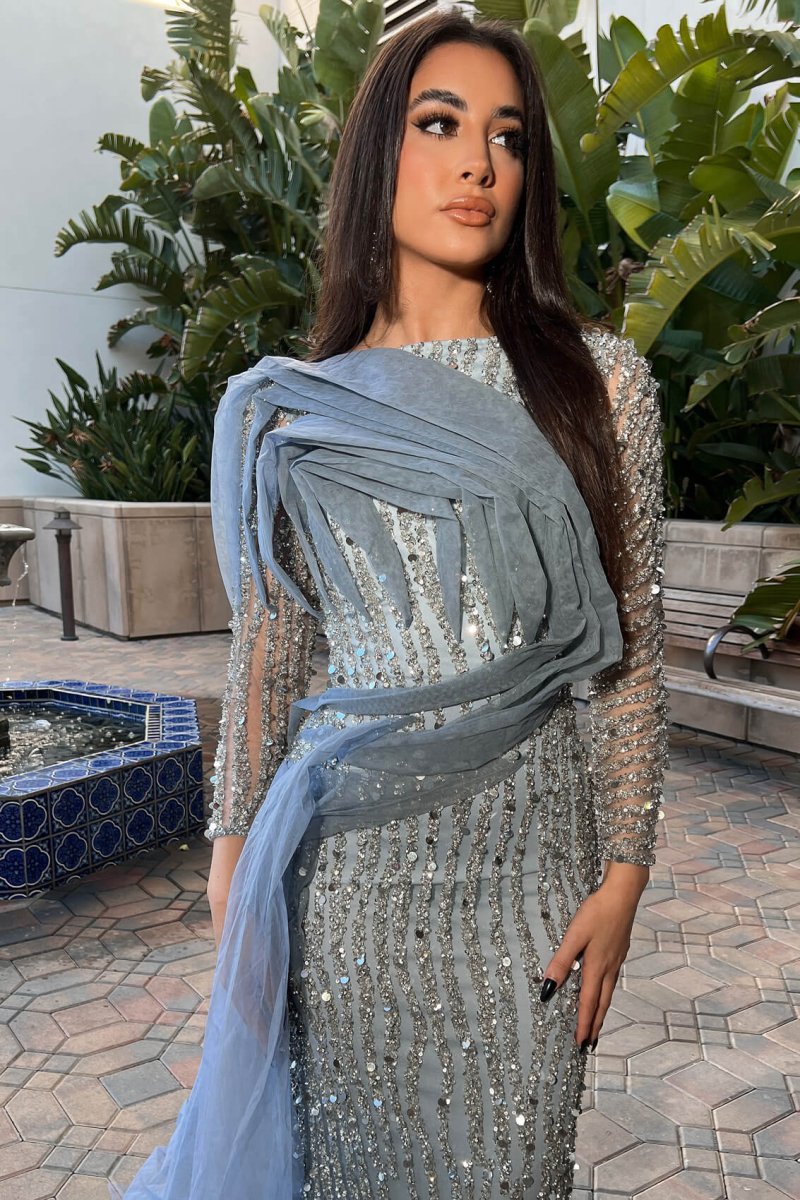 Iyza Belaar Imani long sleeve side skirt dress, a stylish long dress with side slit and elegant design on the fabric.