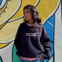 Navy sweatshirt by JZD with anti-racism message, featuring a comfortable fit and bold print on the front.